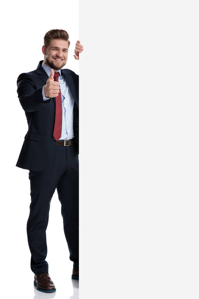 Knappe zakenman gebaren OK naast een lege Billboard - Foto, afbeelding