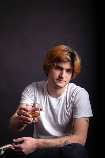 Tipsy young blonde adult holding whiskey - Photo, Image