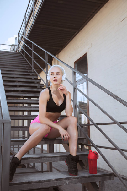 A young athletic woman working out on a stairs outdoors - Фото, зображення