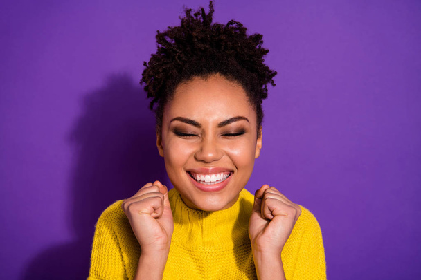 Close up photo of delighted person people raise fists close eyes wear yellow jumper sweater isolated over violet background - Fotó, kép