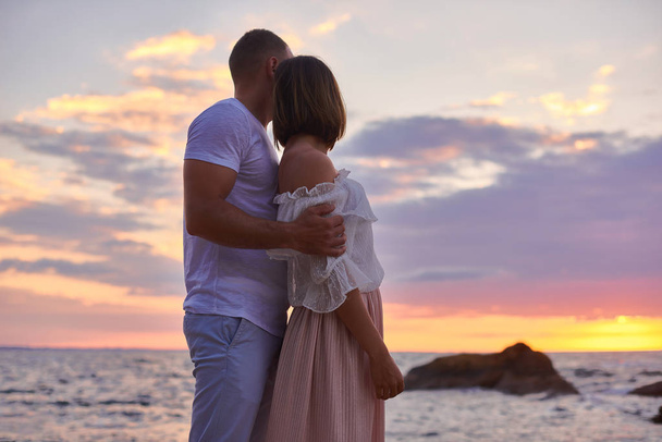 Verliebtes Paar trifft erstaunliche Morgendämmerung an einem wilden Strand - Foto, Bild