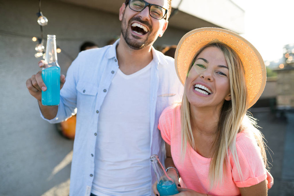 Cheerful young dancing couple having fun and enjoying party at summer - 写真・画像