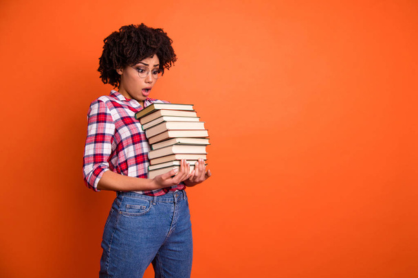 Close up side profile photo beautiful she her model lady oh no expression open mouth hold arms hands many books examination stupor wear casual checkered plaid shirt isolated bright orange background - Foto, Bild