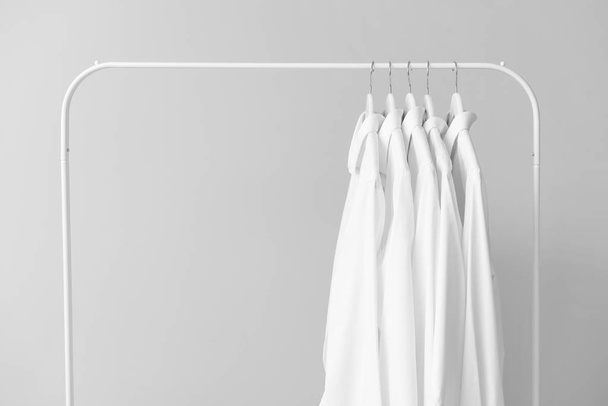 Rack with clothes after dry-cleaning on light background - Φωτογραφία, εικόνα