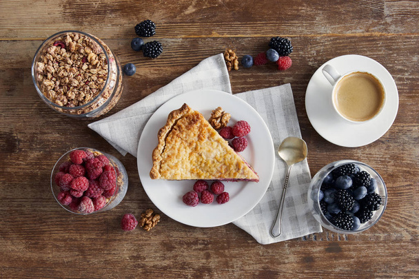 top view of served breakfast with piece of pie, raspberries, oat flakes and cup of coffee - 写真・画像