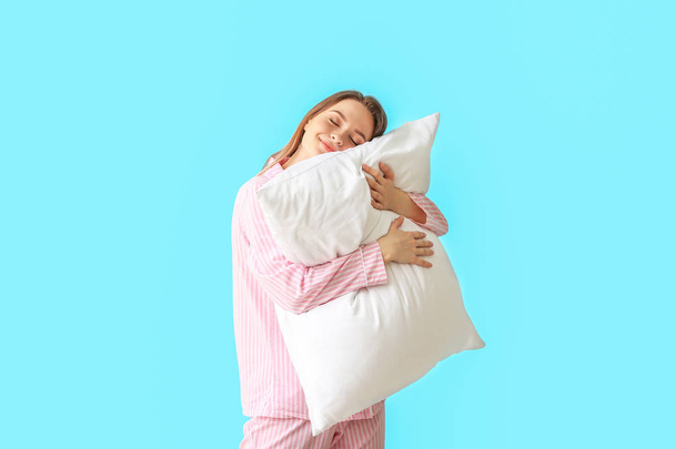 Young woman with pillow on color background - Foto, immagini