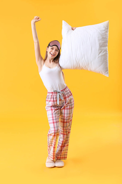 Young woman with pillow and sleep mask on color background - Photo, Image