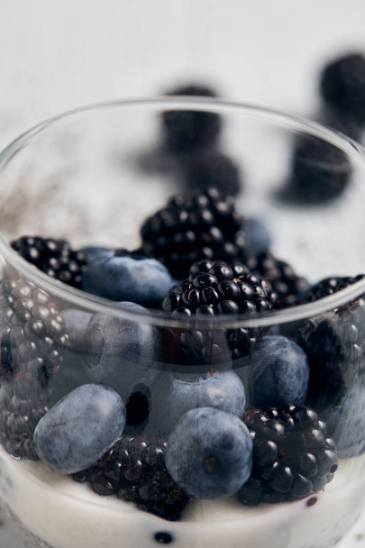 close up view of blackberries, blueberries and yogurt in glass - Foto, Imagem