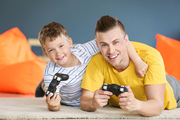 Retrato de padre e hijo jugando videojuegos en casa
 - Foto, imagen