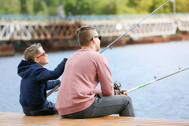 Father and son fishing together on river - Φωτογραφία, εικόνα