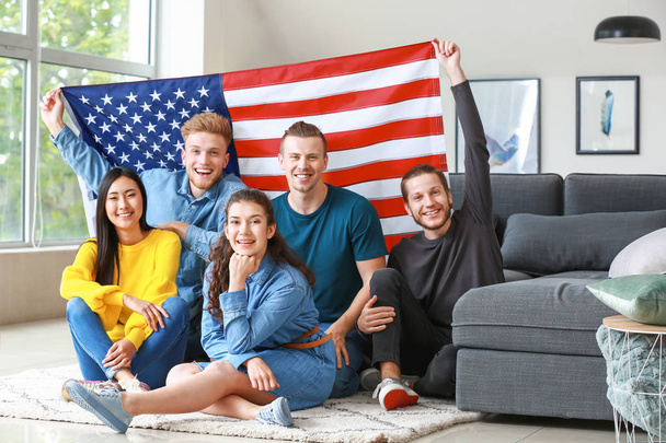 glückliche Freunde mit einer US-Fahne zu Hause. Feier zum Unabhängigkeitstag - Foto, Bild