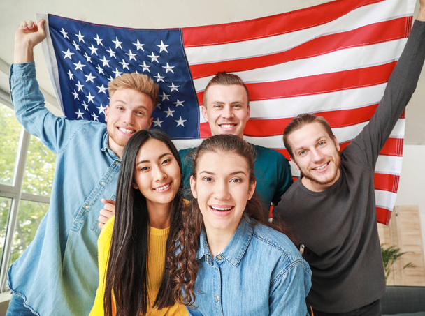 Щасливі друзі з прапором США в домашніх умовах. Святкування Дня незалежності - Фото, зображення