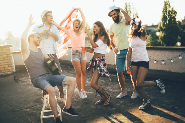 Ryhmä onnellisia ystäviä, joilla on juhla ja hauskaa katolla
 - Valokuva, kuva