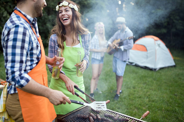 Group of friends having barbecue party in forest - Photo, image