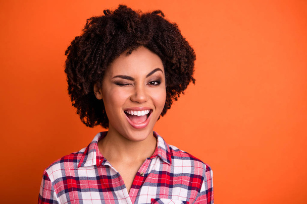 Close-up portrait of her she nice-looking attractive lovable cheerful cheery wavy-haired lady in checked shirt winking isolated on bright vivid shine orange background - Valokuva, kuva