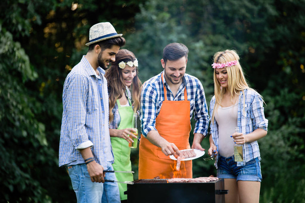 Group of friends having barbecue party in forest - Photo, image