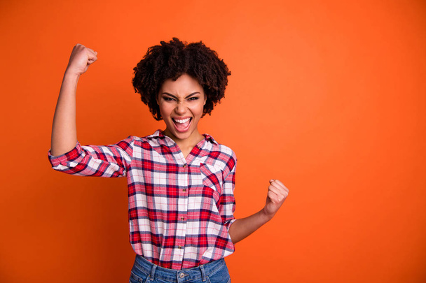 Portrait of her she nice attractive glad ecstatic cheerful cheery wavy-haired lady wearing checked shirt celebrating great winning success isolated over bright vivid shine orange background - 写真・画像