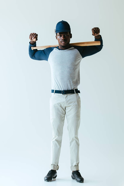 confident african american baseball player looking at camera on grey background - Фото, зображення