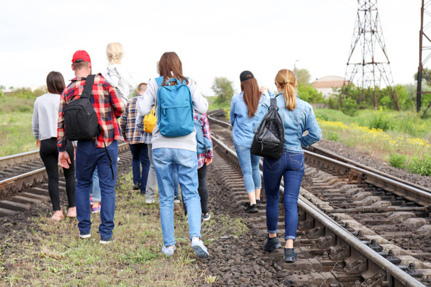 Grupo de inmigrantes ilegales que caminan por vías férreas
 - Foto, Imagen