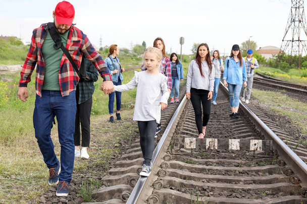 Group of illegal migrants walking along railway tracks - Photo, Image
