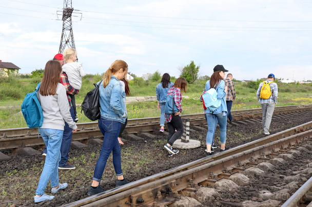 Grupo de inmigrantes ilegales que caminan por vías férreas
 - Foto, imagen