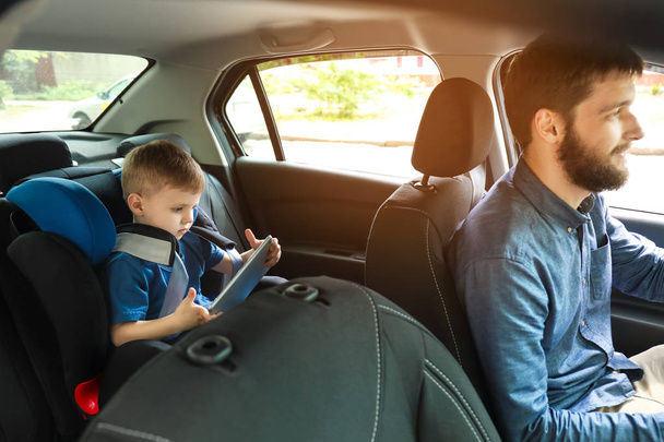 Człowiek jazdy samochodem z synem zapięta w fotelu dziecka - Zdjęcie, obraz