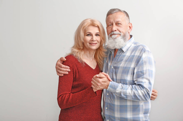Portret van volwassen paar op lichte achtergrond - Foto, afbeelding