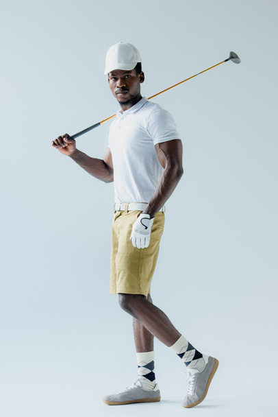 confident african american golf player looking at camera on grey background - Foto, immagini