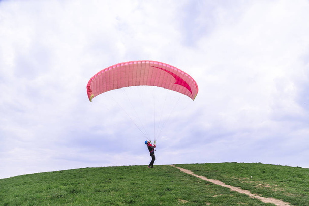 Man landed and tries to drop parachute on ground - Photo, image