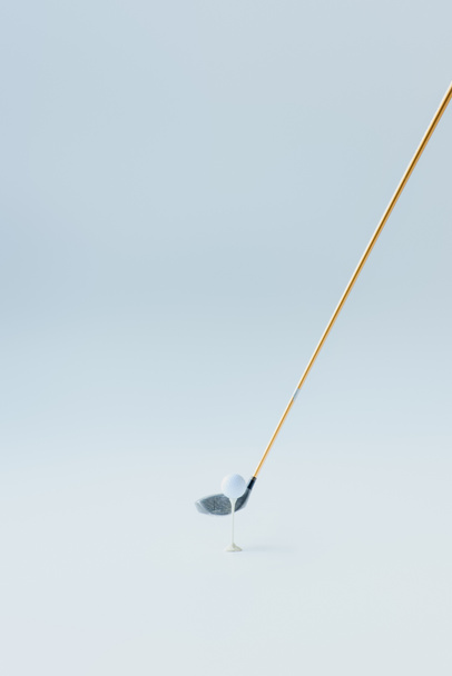 Golfschläger in der Nähe von Golfball am Abschlag auf grauem Hintergrund - Foto, Bild