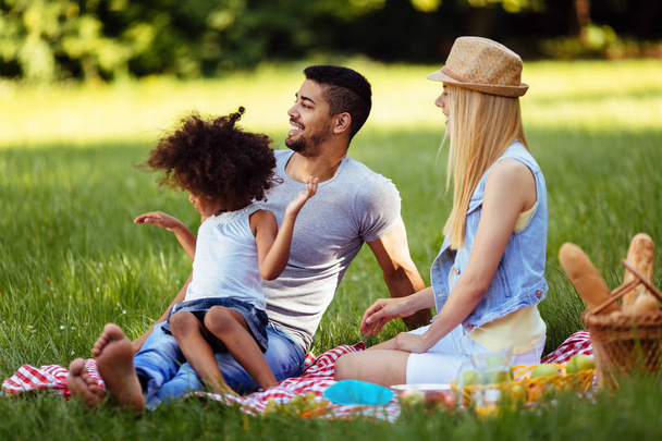 Foto de pareja encantadora con su hija haciendo un picnic en la naturaleza
 - Foto, imagen