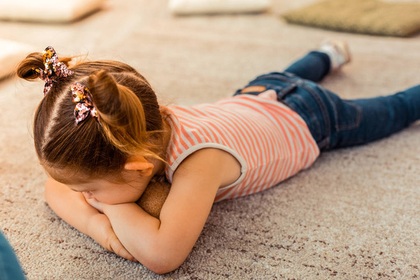 Unhappy tired girl looking at the carpet - Foto, Bild