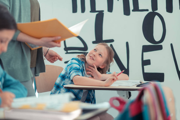 Schoolgirl asking her teacher to give her a cue. - Fotografie, Obrázek