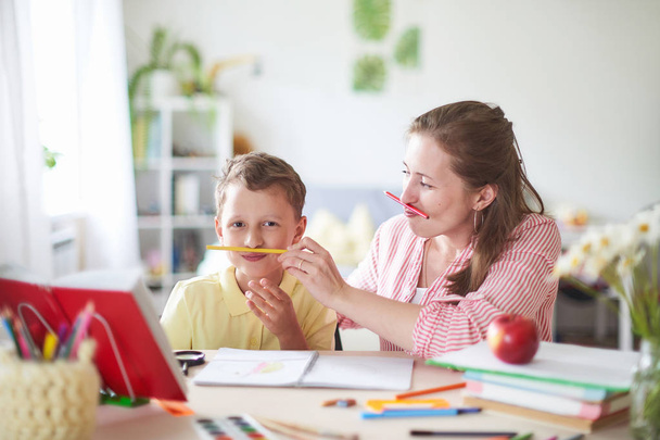 mother helps son to do lessons. home schooling, home lessons. th - Foto, afbeelding