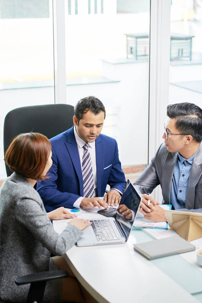 Група багатоетнічних бізнесменів, що сидять за столом, обговорюють бізнес-план в команді під час ділової зустрічі в офісі
 - Фото, зображення