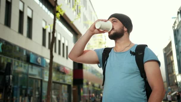 Young beautiful bearded man drinking coffee on the streets of city - Filmmaterial, Video