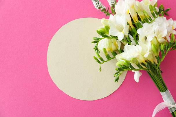 Blanco kaart en mooie Freesia bloemen op kleur achtergrond - Foto, afbeelding