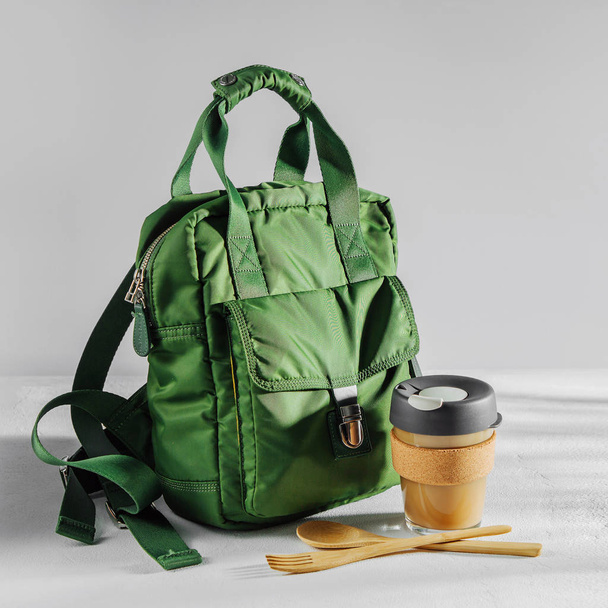 Green backpack with reusable coffee mug - Foto, Bild