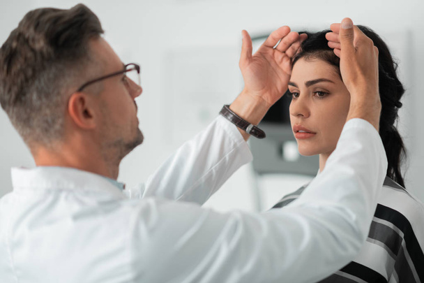 Woman standing calm while plastic surgeon making face measurements - Foto, Bild