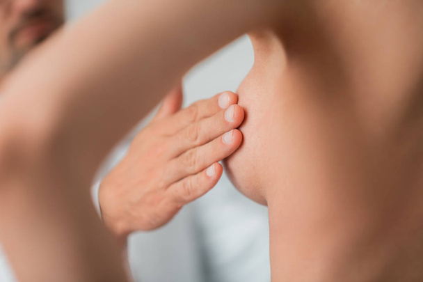 Close up of plastic surgeon touching nipples before augmentation - Fotó, kép