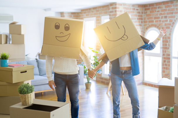 Grappig paar het dragen van kartonnen dozen met leuke gekke Emoji gezichten  - Foto, afbeelding