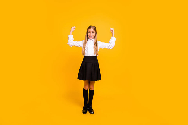 Full length body size view of her she nice attractive cheerful cheery straight-haired pre-teen girl having fun demonstrating muscles isolated on bright vivid shine yellow background - Foto, immagini