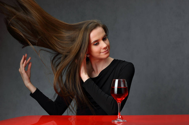 Cute girl at the red table with a glass of wine - Foto, Imagem