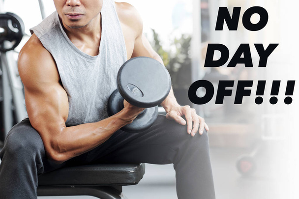 Strong man exercising with dumbbells, no day off inscription near him - Foto, immagini