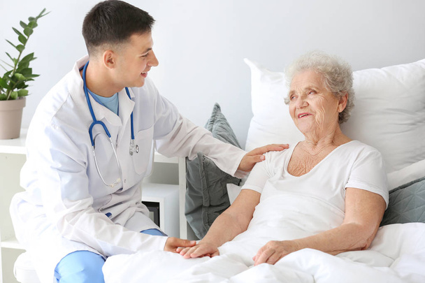Arzthelferin mit Seniorin im Pflegeheim - Foto, Bild