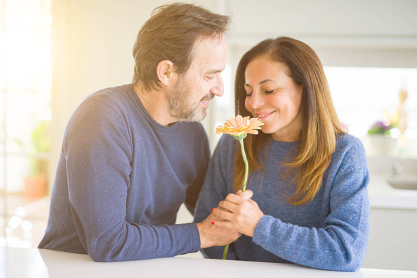Romantic middle age couple holding flowers in love at home - Photo, Image