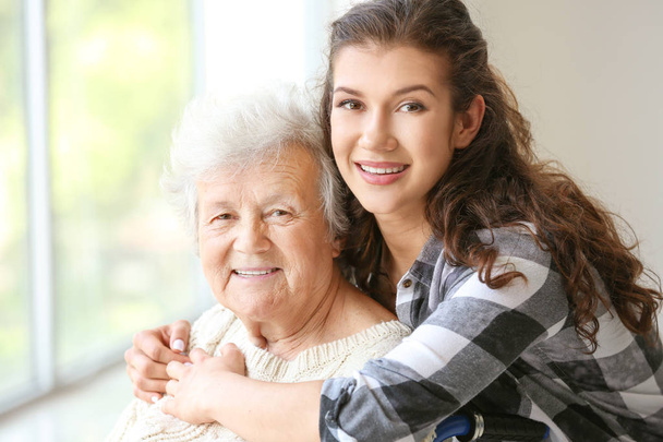 Senior vrouw met haar kleindochter in verpleeghuis - Foto, afbeelding