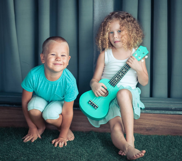 Portrait of a cute kids with ukulele - Foto, Imagen