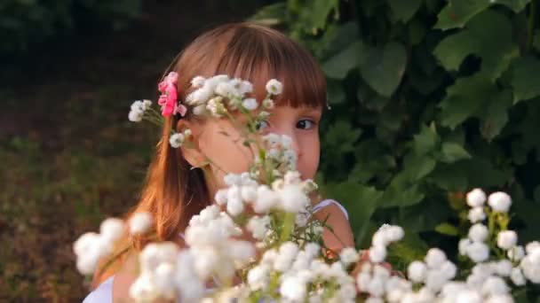 The girl among flowers smiles waves a hand - Záběry, video