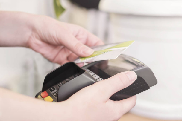 Primer plano de la mano de la mujer que paga con tarjeta inteligente sin contacto
 - Foto, Imagen